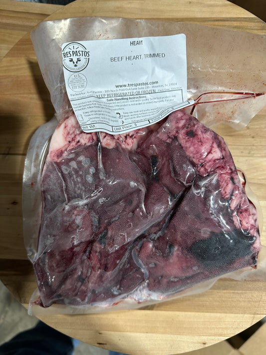 Packaged 100% Wagyu beef heart meat on a wooden cutting board with a label attached to it.